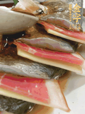 魚肚中塞蔥結、火腿片，魚身上碼放姜片、火腿片，倒入混合的料汁。